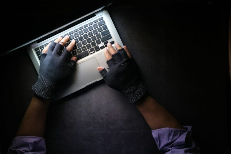 Man typing at a keyboard in the dark